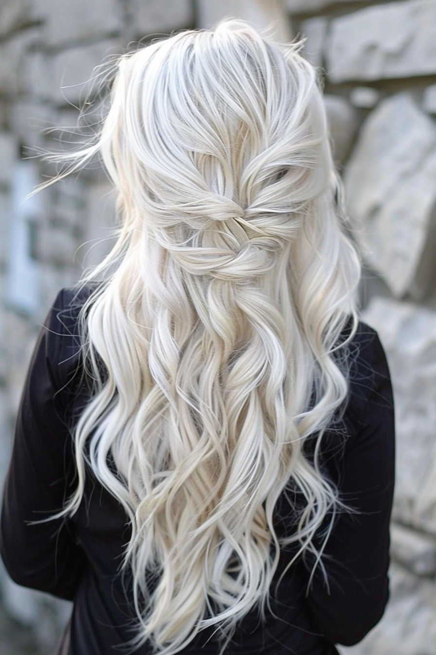 Long wavy hairstyle. Platinum blonde with soft side braid.