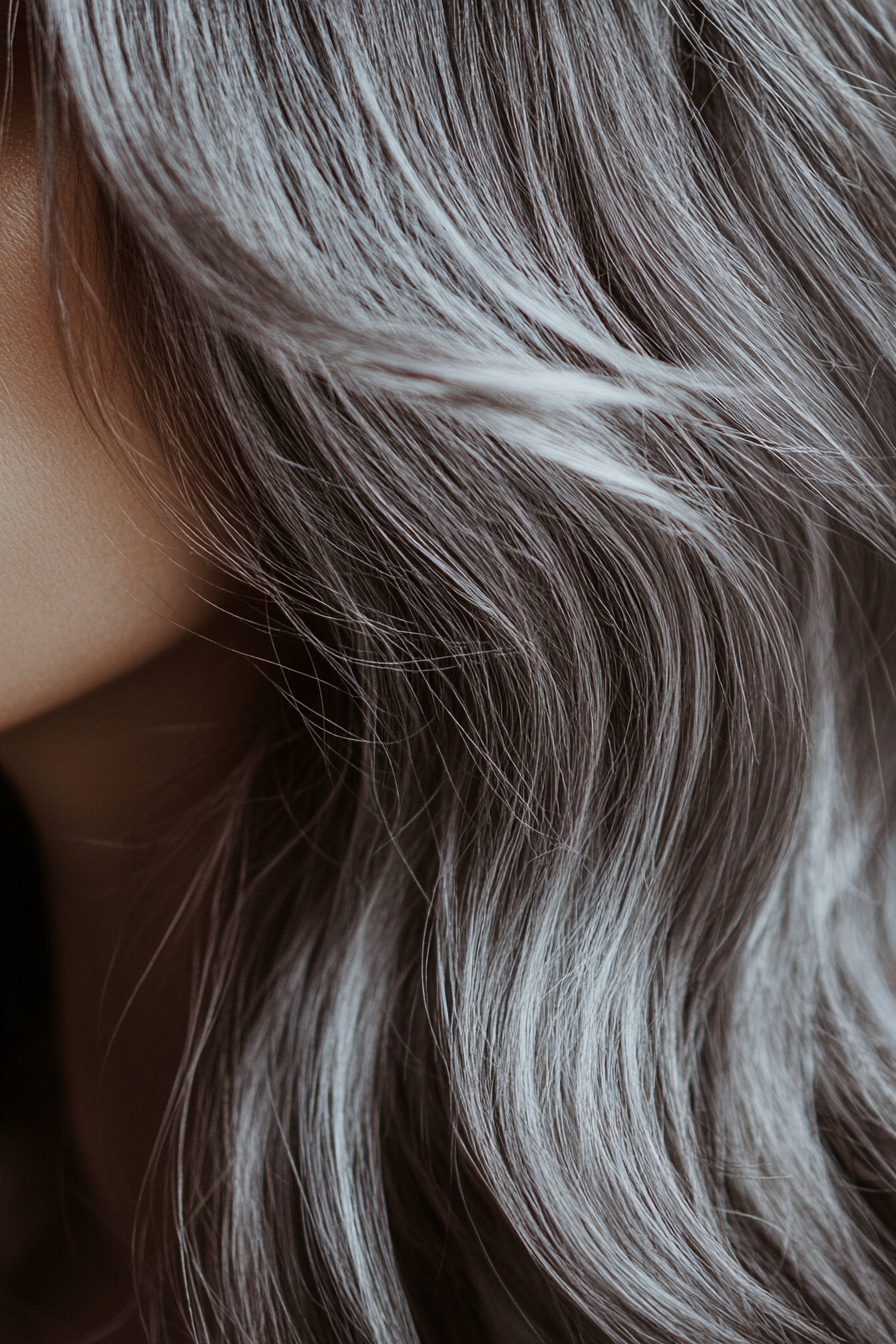 Hair color style for women. Chestnut brown shadow roots with silver toning and regular maintenance.